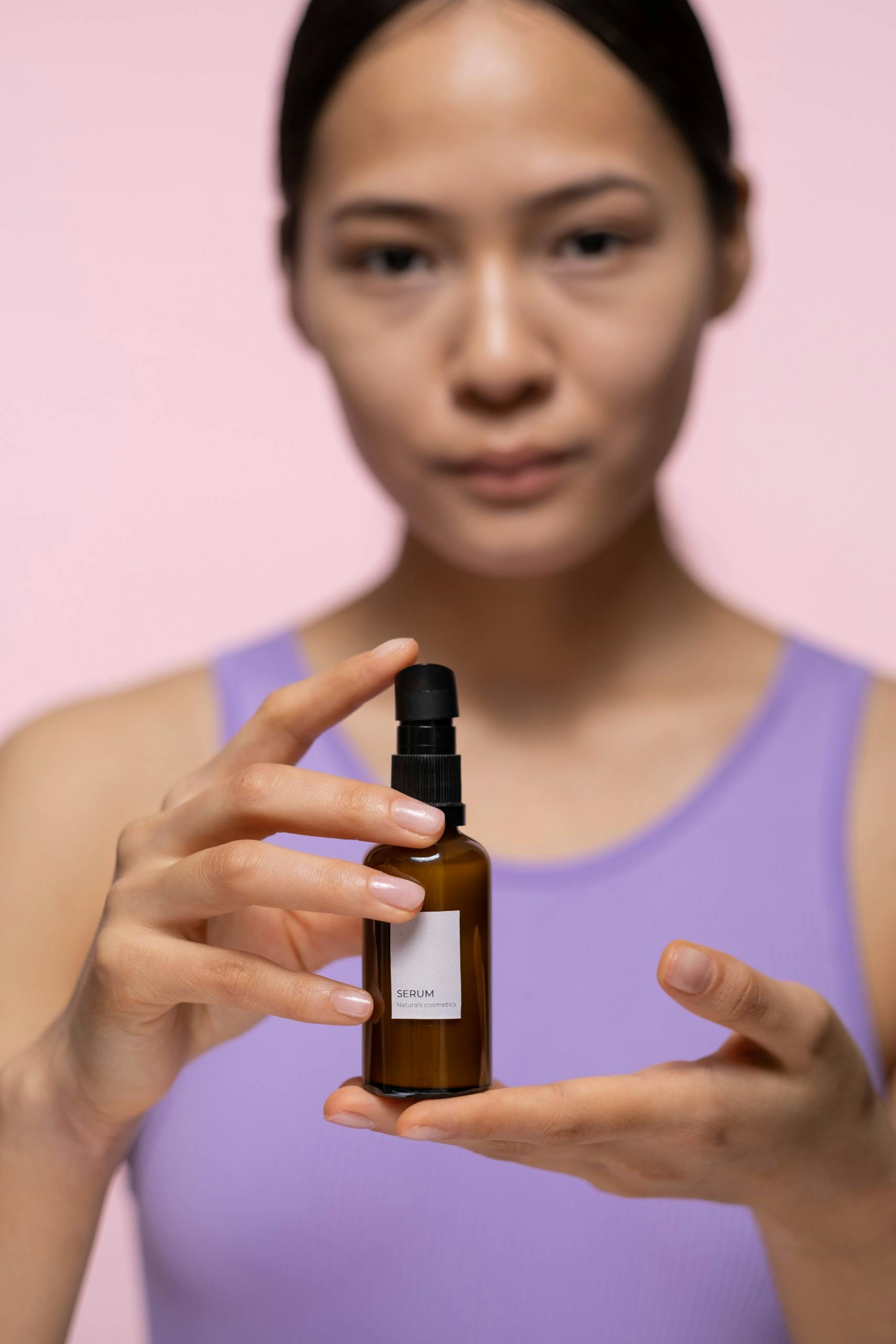 Woman Holding Brown Glass Bottle